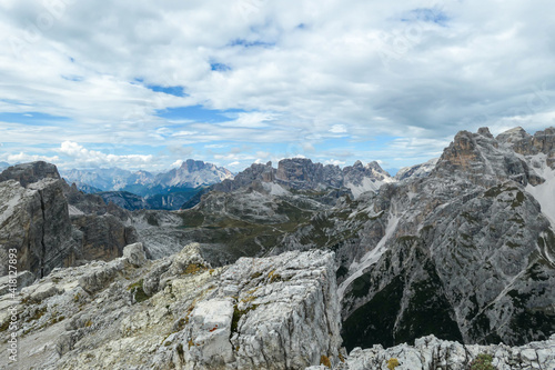 Wallpaper Mural An endless view on a high and desolated mountain peaks in Italian Dolomites. The lower parts of the mountains are overgrown with moss and grass. Raw and unspoiled landscape. Few clouds above the peaks Torontodigital.ca