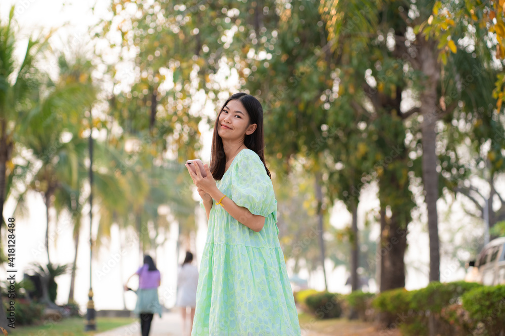 Beautiful casual women use smartphone walking in outdoor city park Beautiful casual women use smartphone walking in outdoor city park