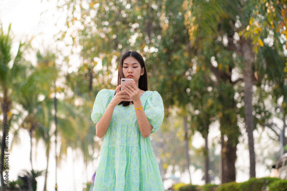 Beautiful casual women use smartphone walking in outdoor city park Beautiful casual women use smartphone walking in outdoor city park
