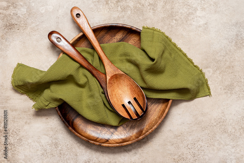 Various wooden kitchen utensils on a light concrete background top view. Copy space for text.