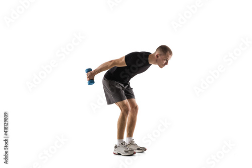 Dumbbells. Young caucasian male model in action, motion isolated on white background with copyspace. Concept of sport, movement, energy and dynamic, healthy lifestyle. Training, practicing. Authentic. © master1305