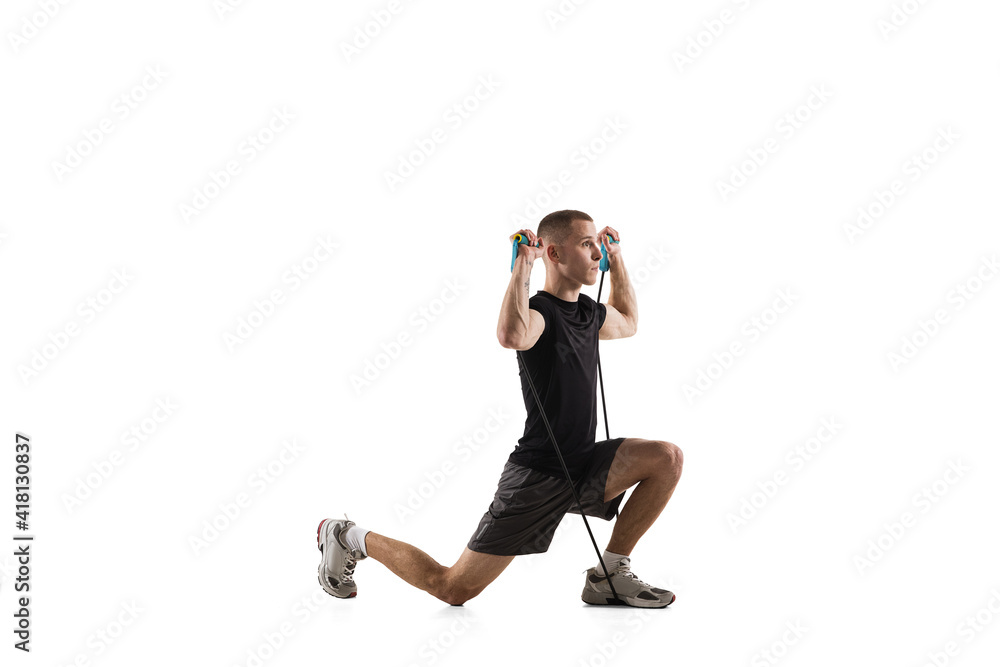 Fototapeta premium Work out. Young caucasian male model in action, motion isolated on white background with copyspace. Concept of sport, movement, energy and dynamic, healthy lifestyle. Training, practicing. Authentic.