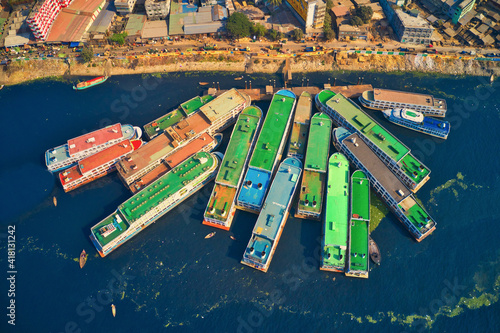 Aerial view of colourful ferry boat docket at small wharf along Buriganga river in Keraniganj, Dhaka, Bangladesh.