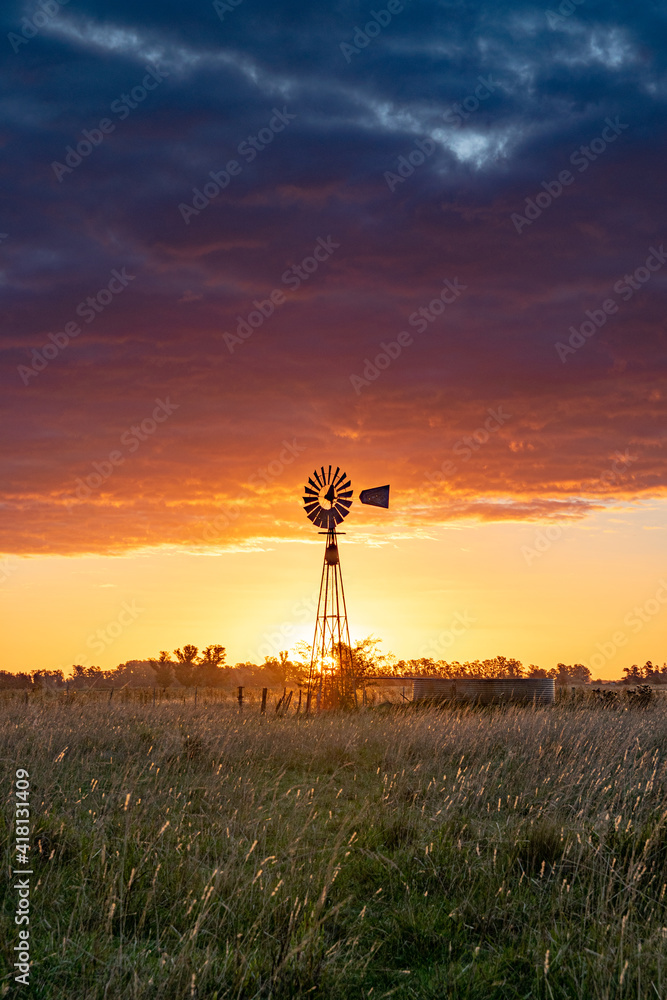 Windmill in the sunset, at the fields of Buenos Aires, Argentina