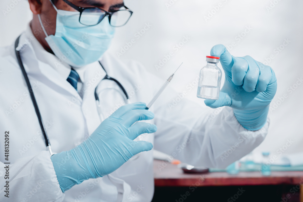 A doctor or laboratory scientist holds a syringe with a vaccine against the COVID 19 for new patients. Concept of protection against new virus strains
A doctor or laboratory scientist holds a syringe with a vaccine against the COVID 19 for new patients. Concept of protection against new virus strains