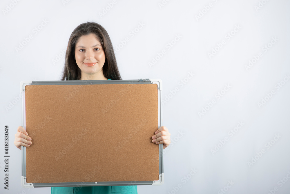 Smiling young nurse holding board with hand on white background Smiling young nurse holding board with hand on white background