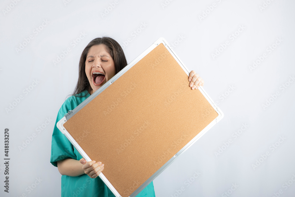 Scared and screaming young nurse holding board Scared and screaming young nurse holding board