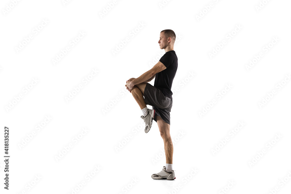 Stretching. Young caucasian male model in action, motion isolated on white background with copyspace. Concept of sport, movement, energy and dynamic, healthy lifestyle. Training, practicing. Authentic Stretching. Young caucasian male model in action, motion isolated on white background with copyspace. Concept of sport, movement, energy and dynamic, healthy lifestyle. Training, practicing. Authentic