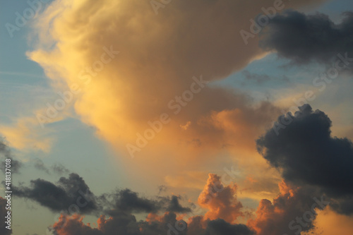 Fluffy yellow and purple clouds bathed in sunset light