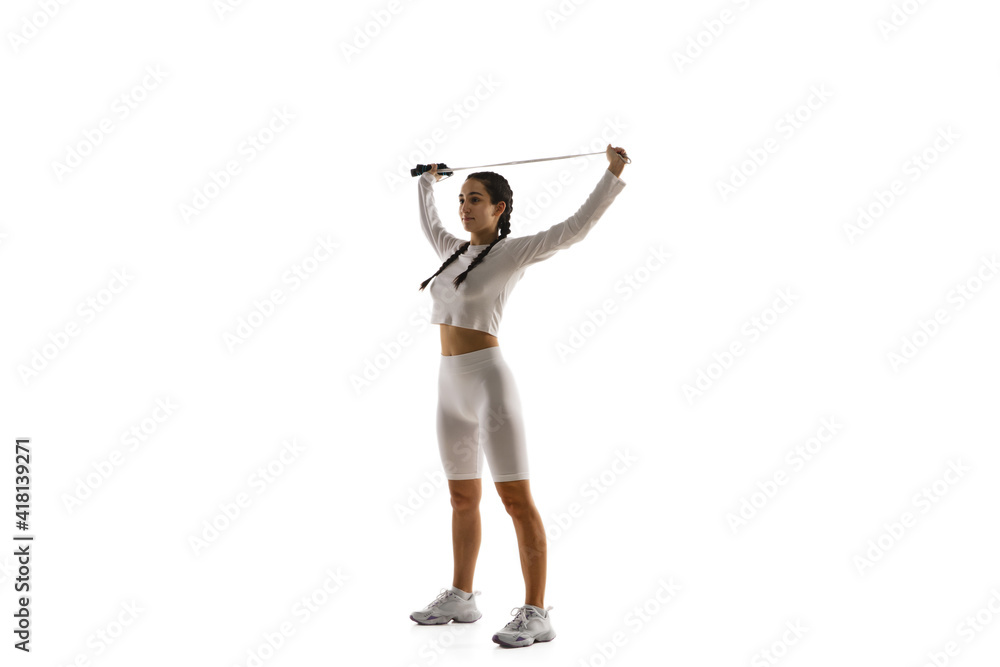 Jamping rope. Young caucasian female model in action, motion isolated on white background with copyspace. Concept of sport, movement, energy and dynamic, healthy lifestyle. Training, practicing. Jamping rope. Young caucasian female model in action, motion isolated on white background with copyspace. Concept of sport, movement, energy and dynamic, healthy lifestyle. Training, practicing.