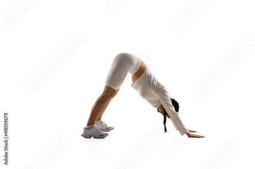Yoga. Young caucasian female model in action, motion isolated on white background with copyspace. Concept of sport, movement, energy and dynamic, healthy lifestyle. Training, practicing.