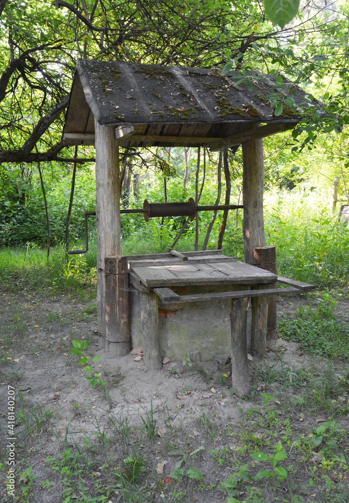 © bildlove - An outdoor old-fashioned, old hand made water well with a wooden roof in the garden. Restoring an old water well. © bildlove - An outdoor old-fashioned, old hand made water well with a wooden roof in the garden. Restoring an old water well.