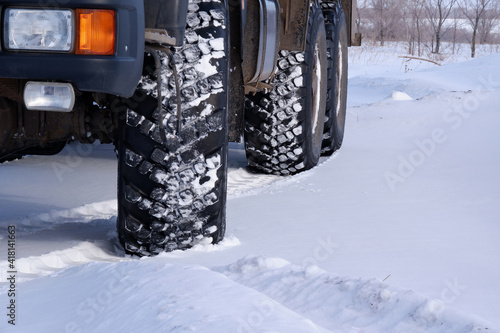 Winter. A truck on wheels with a large tread for driving on snow. Part of the photo is blurred. © A08
