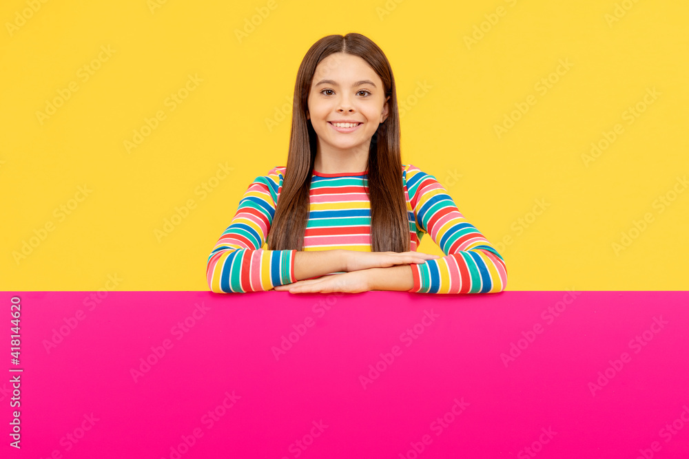 place for promotion and creativity. for your marketing design. cheerful teen girl with paper banner. place for promotion and creativity. for your marketing design. cheerful teen girl with paper banner.