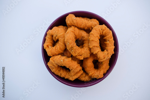 Top view of south indian traditional snack item, evening tea time item Chegodilu or Ring murukku isolated on white background in white plate served during festival photo