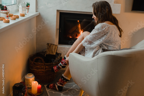 Photography the beautiful woman is chilling at home near fireplace