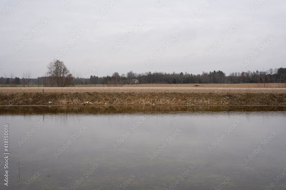 Flooded meadow in early spring when snow has just melted in the Latvian