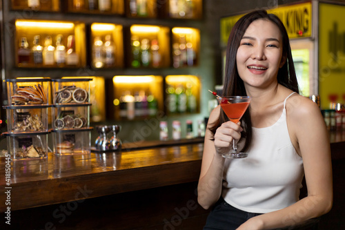 Asian alone women enjoy cocktails in front of a vintage bar  Relaxing activities after work or hangouts  Place of entertainment for young adolescents or night club party.
