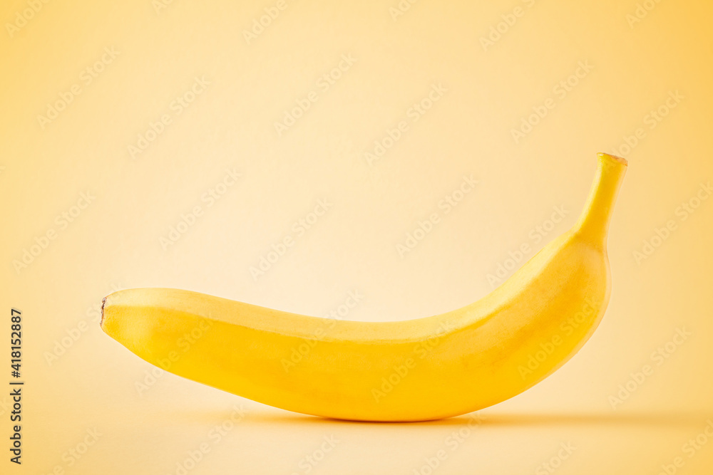 Banana on pastel yellow background with copy space. Minimalist concept. Bold color fresh fruit in soft light. Banana on pastel yellow background with copy space. Minimalist concept. Bold color fresh fruit in soft light.