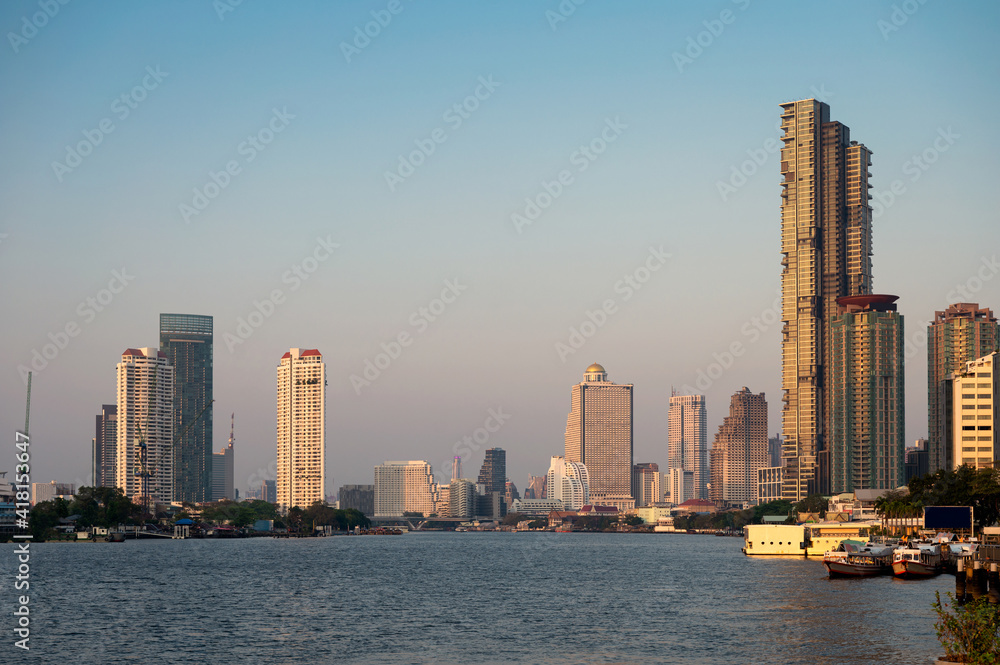 Bangkok city with sunshine on high-rise buildings in downtown on Chao Phraya riverside