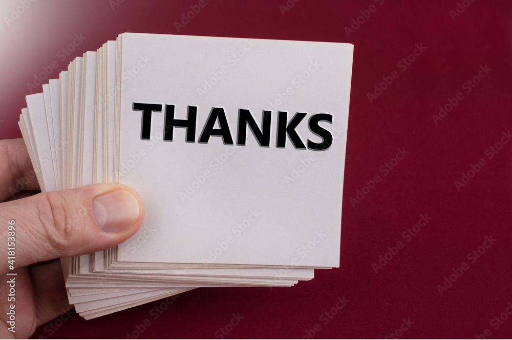 Thanks sign on a white paper note on a red Thanks sign on a white paper note on a red