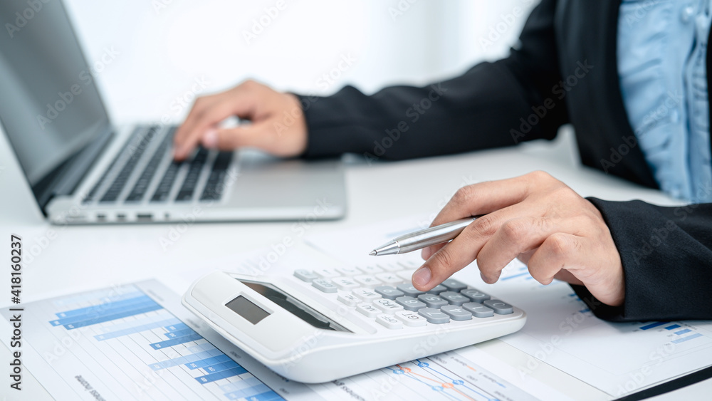 Business woman use calculator to calculate investment figures Business woman use calculator to calculate investment figures