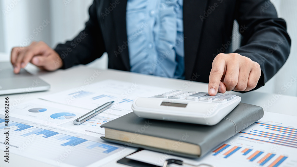 Business woman press calculator to calculate investment data Business woman press calculator to calculate investment data