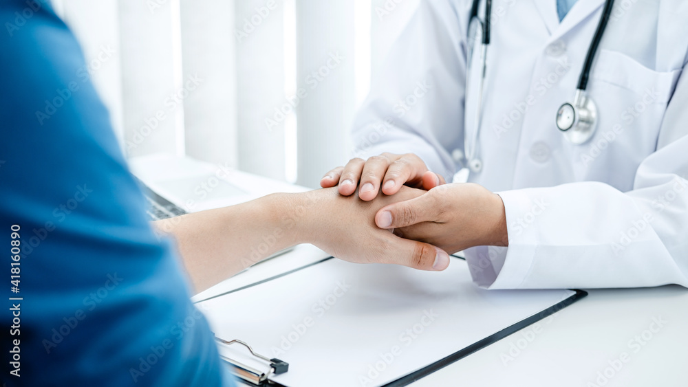 Doctor holding touching hand after reading bad result at clinic Doctor holding touching hand after reading bad result at clinic