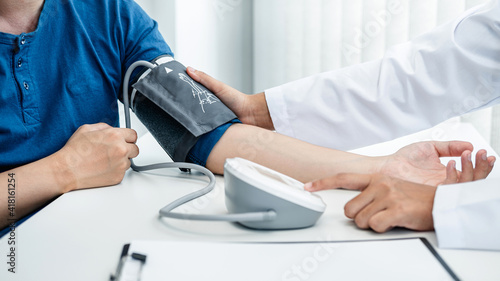 Doctor is checking the patient blood pressure in his hospital office