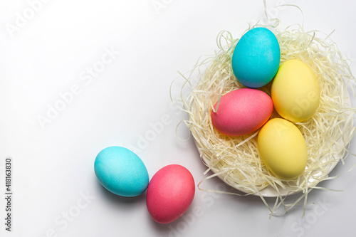 Colorful Easter eggs in nest isolated on white background. Happy Easter card, copy space, close-up