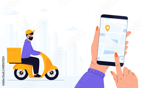 COVID-19. Quarantine. Coronavirus epidemic. Delivery man in a protective mask delivers parcel by motorbike. Track shipments using the mobile application. Hand is holding smartphone