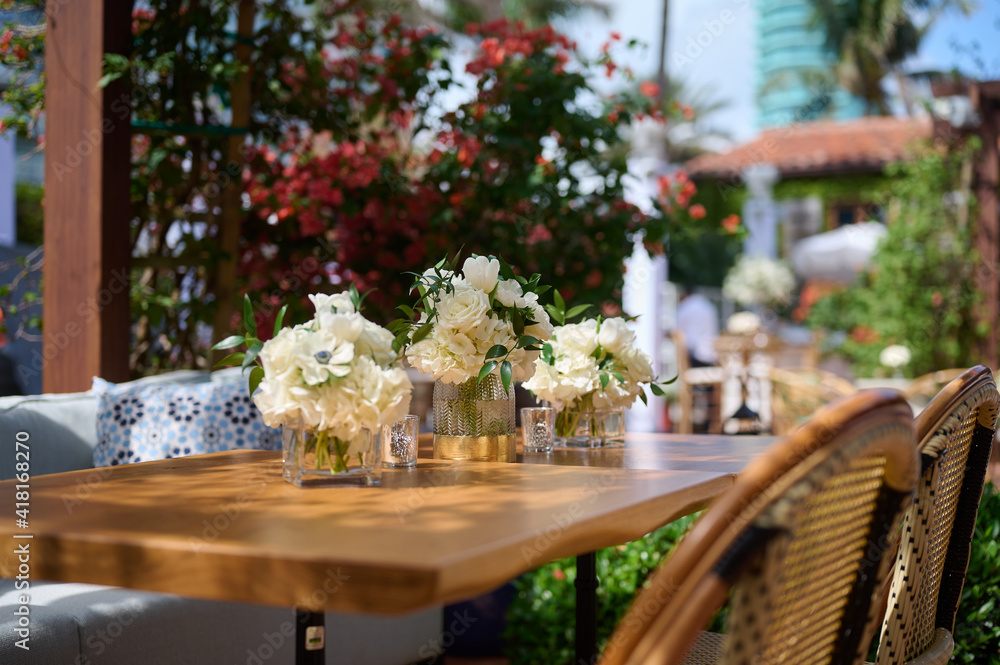 Table setting with vases with white flowers on the terrace