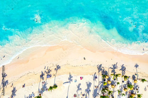 Beach vacation and travel background. Aerial drone view of beautiful atlantic tropical beach with straw umbrellas and palms. Bavaro beach, Punta Cana, Dominican Republic. photo