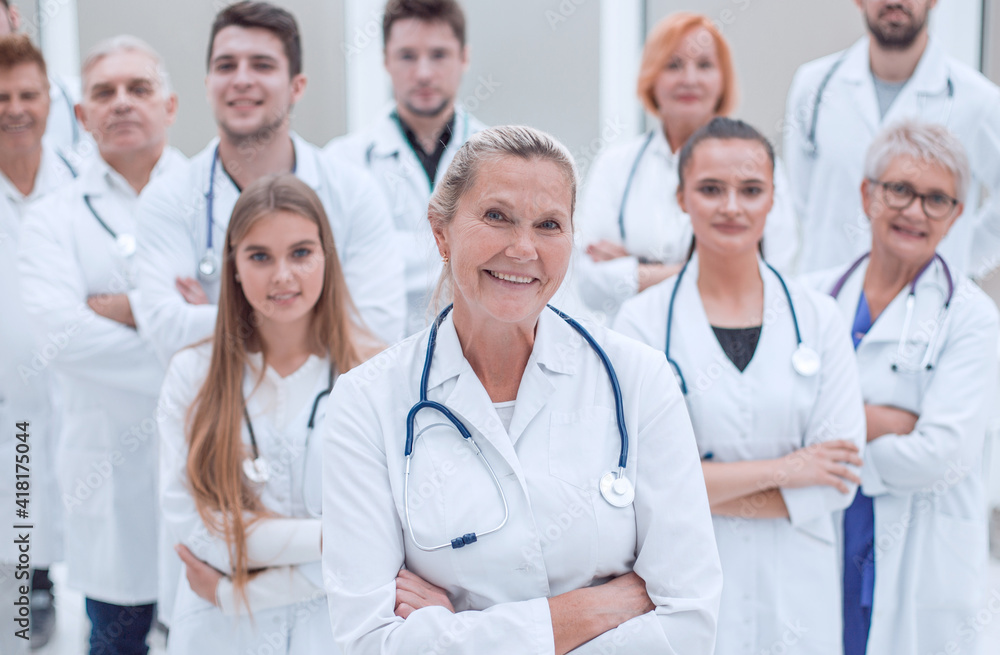 adult female doctor and a group of her colleagues standing together. adult female doctor and a group of her colleagues standing together.