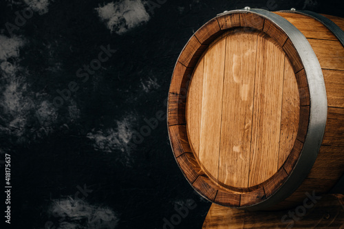 A beautiful wooden barrel and a worn oak wood table set against a dark wall pattern for the design