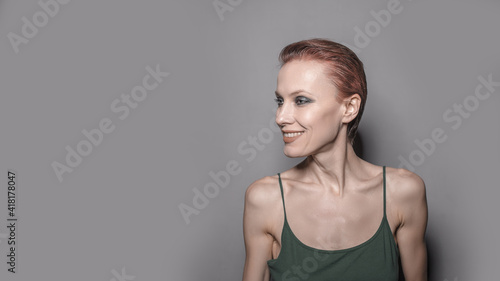 young woman close up portrait. Beautiful female indoor. Red-haired girl. Redhead with short hair over grey background 