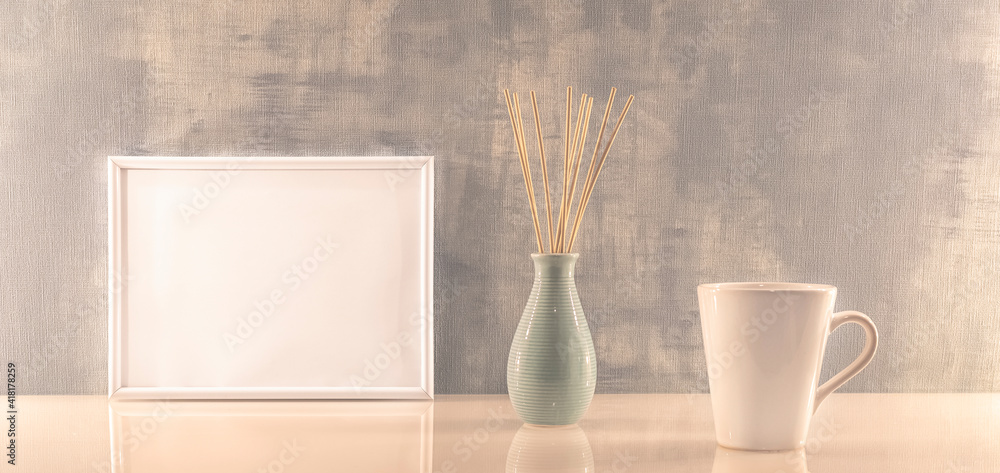 Modèle de cadre photo blanc avec espace vide pour logos, inscription publicitaire. Cadre en mode paysage sur un espace de travail avec une tasse. Ambiance zen.	
