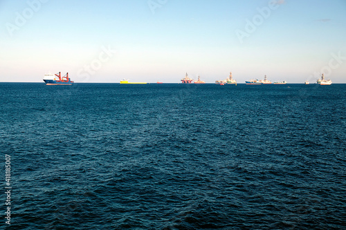 Oil rigs, tugs and various service ships anchored in the outer harbour waiting for refueling and repair.