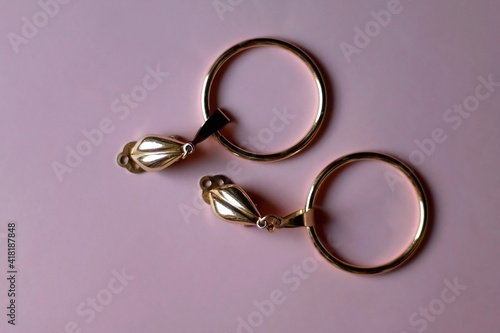 Vintage golden earrings on pink background. Top view. 