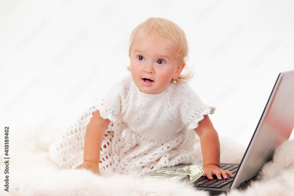 Little baby girl with blond hair in white dress plays with laptop Little baby girl with blond hair in white dress plays with laptop