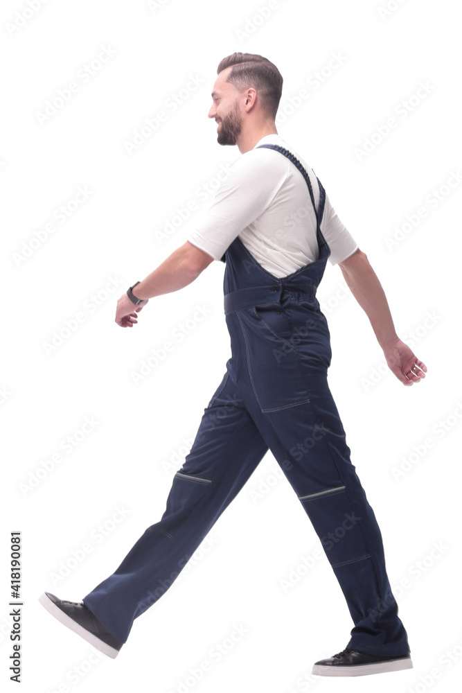 side view. smiling man in overalls confidently striding forward side view. smiling man in overalls confidently striding forward