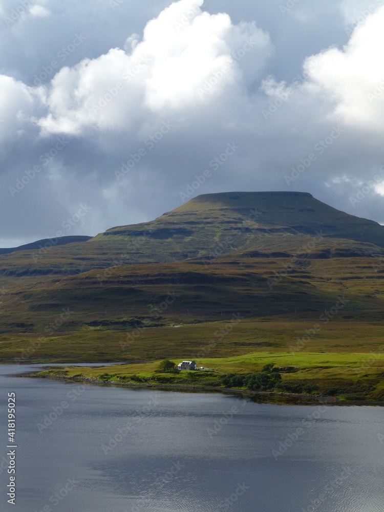 View across Loch Dunvegan to Healabhal Mhor (Macleod's Table), Isle of Skye with house on shores of the loch and rain clouds forming above the mountain View across Loch Dunvegan to Healabhal Mhor (Macleod's Table), Isle of Skye with house on shores of the loch and rain clouds forming above the mountain