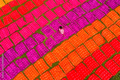 Aerial view of a woman working placing colourful towels in a field near Araihazar, Dhaka district, Bangladesh. photo