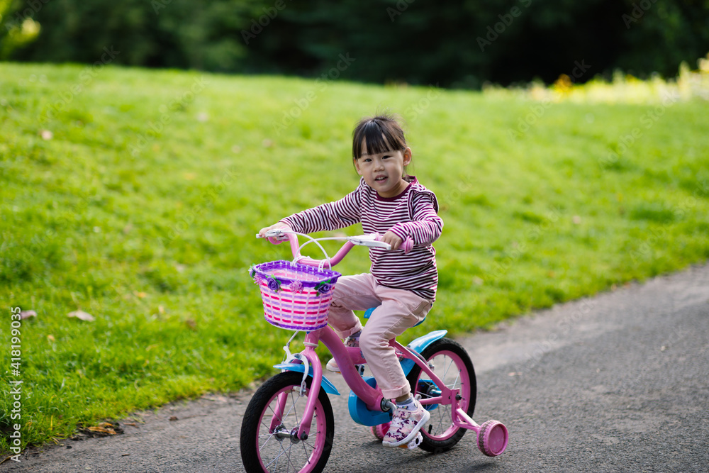 young girl ridding bicycle in the summer garden morning young girl ridding bicycle in the summer garden morning
