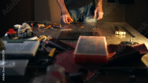 Cropped portrait of craftsman working with leather in tannery workshop. Small business concept.