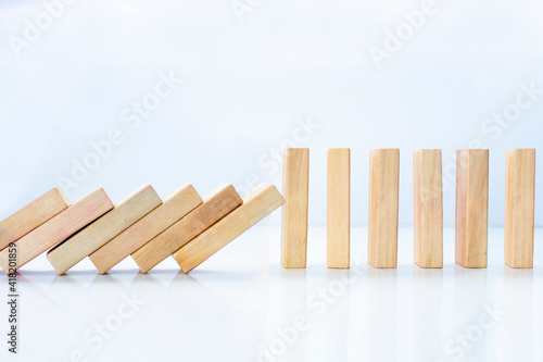 Wooden pieces domino effect stopping with stand wooden pieces. Concept: Business crisis and risk protection concept.