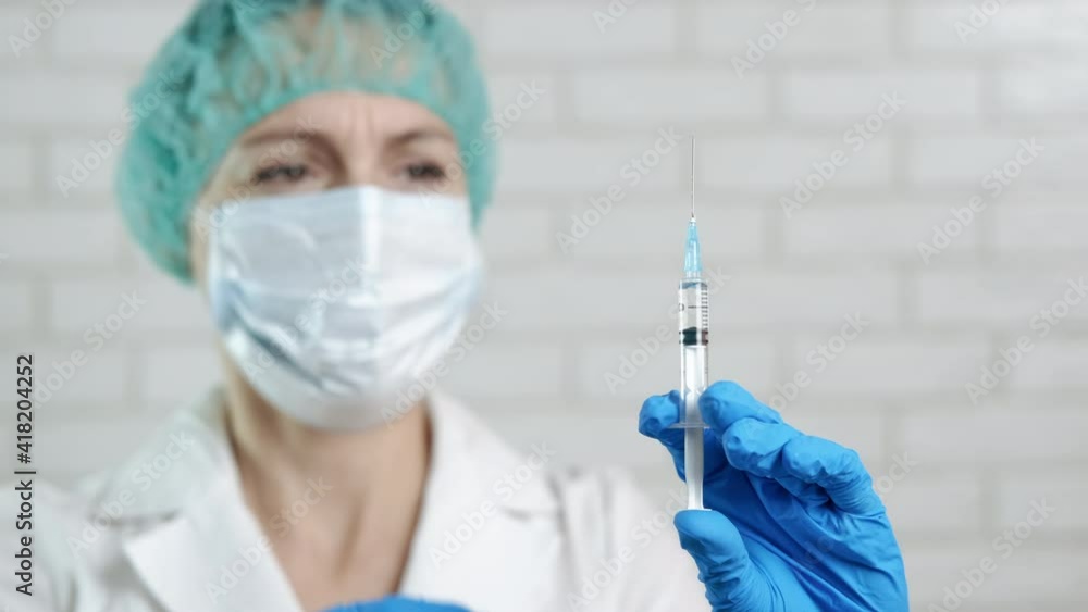 Nurse hands with a vaccine injection. A doctor prepare an injection with a vaccine in the office. Nurse hands with a vaccine injection. A doctor prepare an injection with a vaccine in the office.