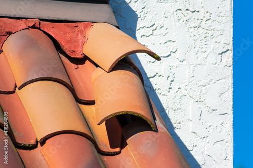 Roof tiles dislodged by strong winds during storm require repair to prevent water leak and interior damage