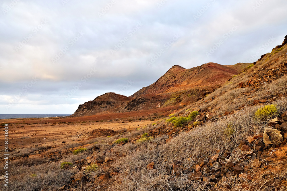 Landscape of a volcanic island in extremely warm sunset light.