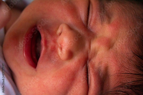 close up of the face of a newborn hispanic baby